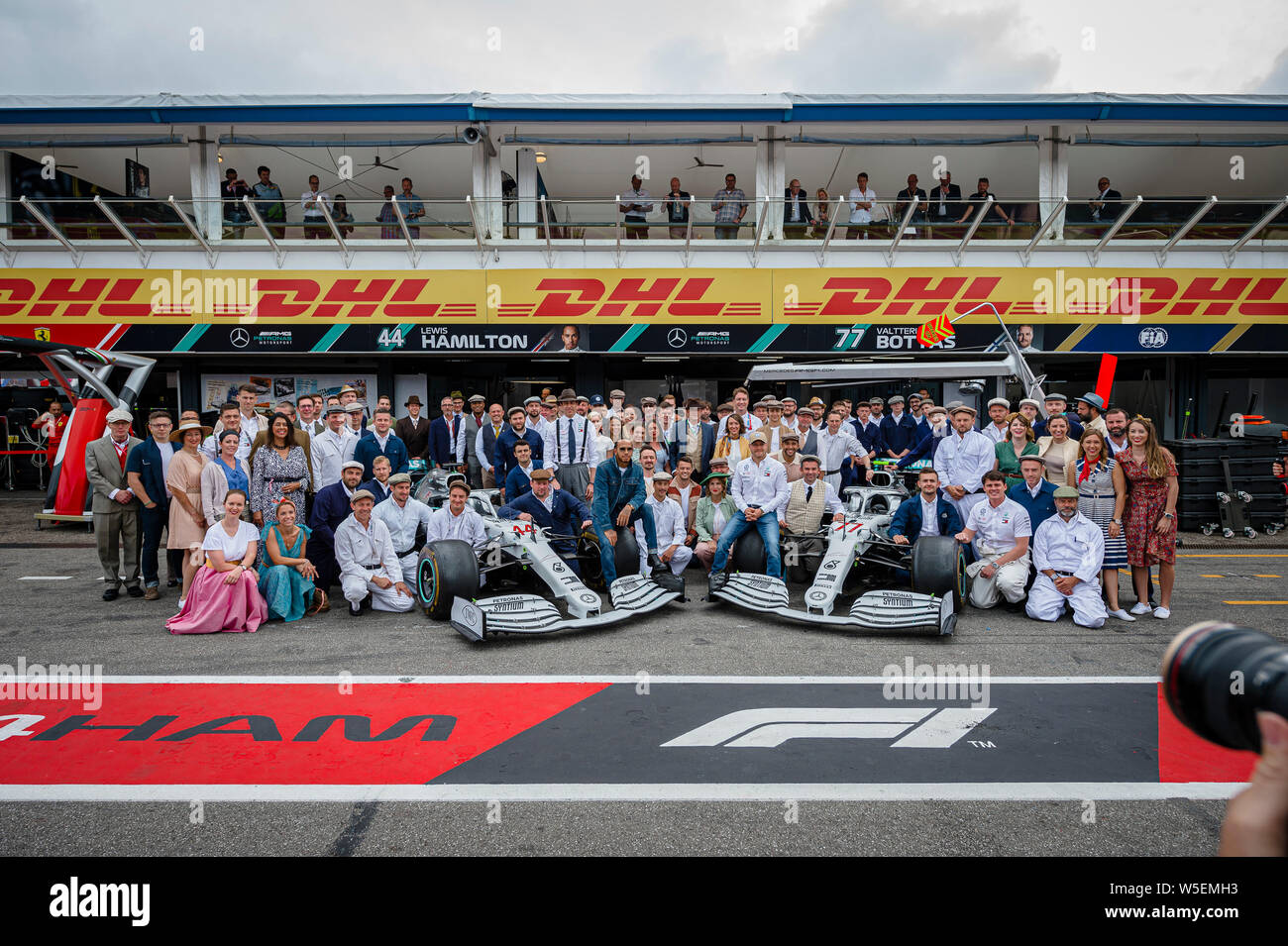 Hockenheim, Germany. 28th July, 2019. Mercedes AMG Petronas F1 Team members pose for a photo prior to the start of the German F1 Grand Prix race, to celebrate 125 years of racing and their 200 starts in Grand Prix races. Credit: SOPA Images Limited/Alamy Live News Stock Photo
