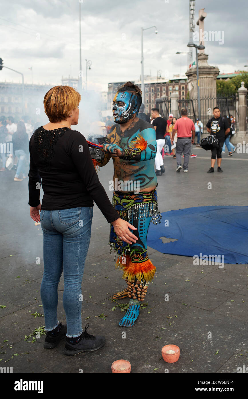 Mexican woman receiving copal spiritual 'cleansing' ritual at the Zocalo, Mexico City, CDMX, Mexico. Jun 2019 Stock Photo