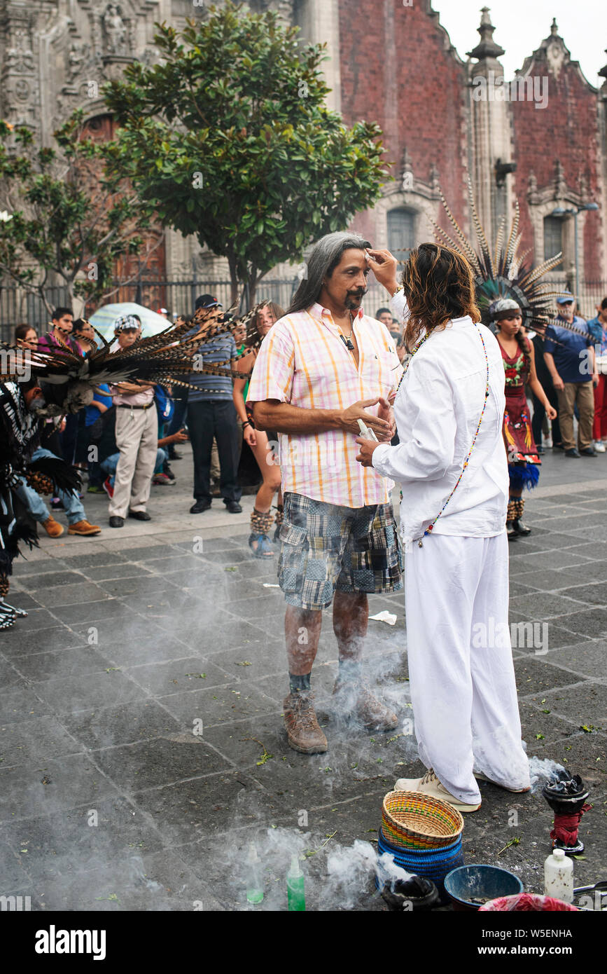 Mexican latino man receiving copal spiritual 'cleansing' ritual at the Zocalo, Mexico City, CDMX, Mexico. Jun 2019 Stock Photo