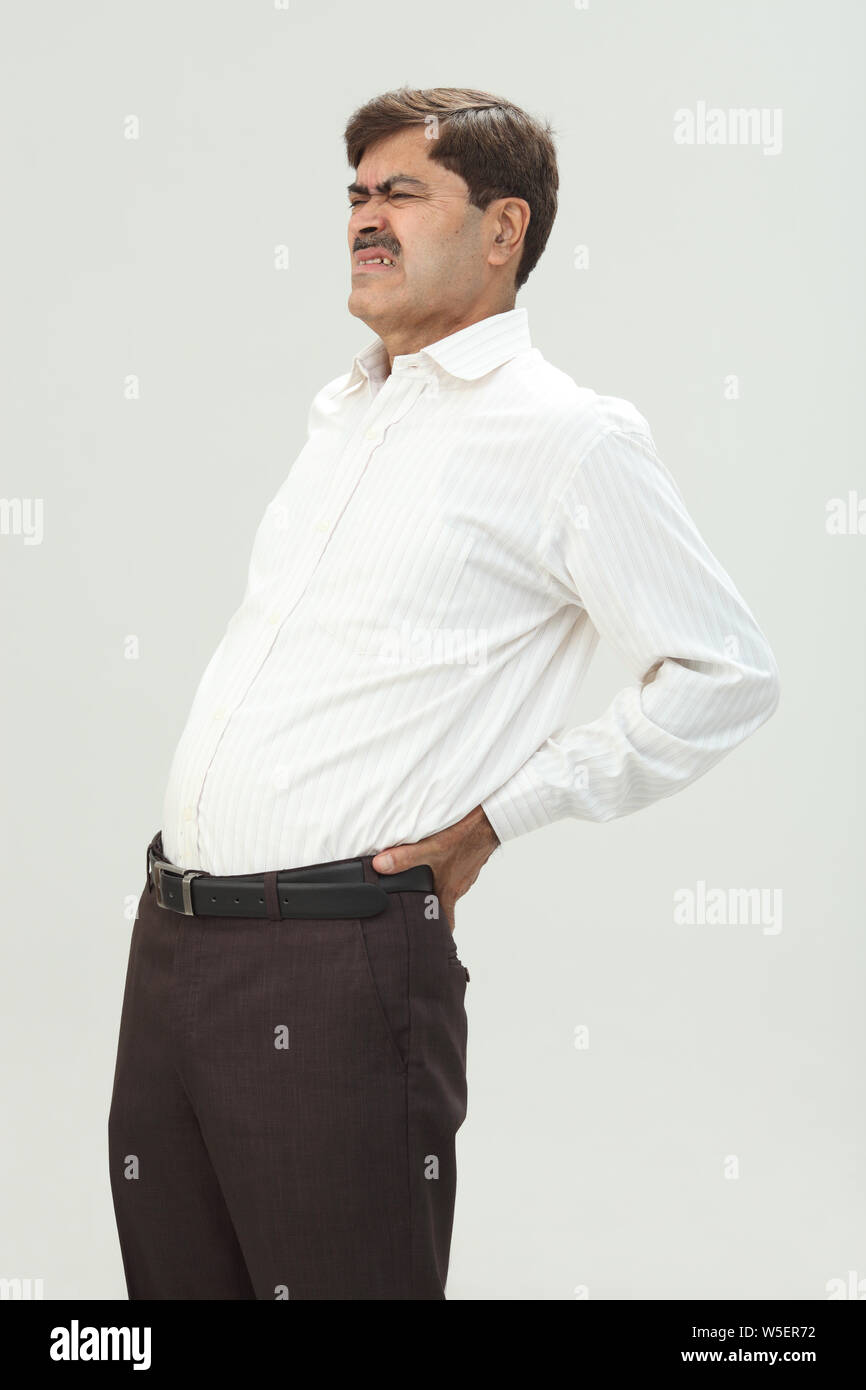 Indian businessman suffering from lower back pain Stock Photo - Alamy