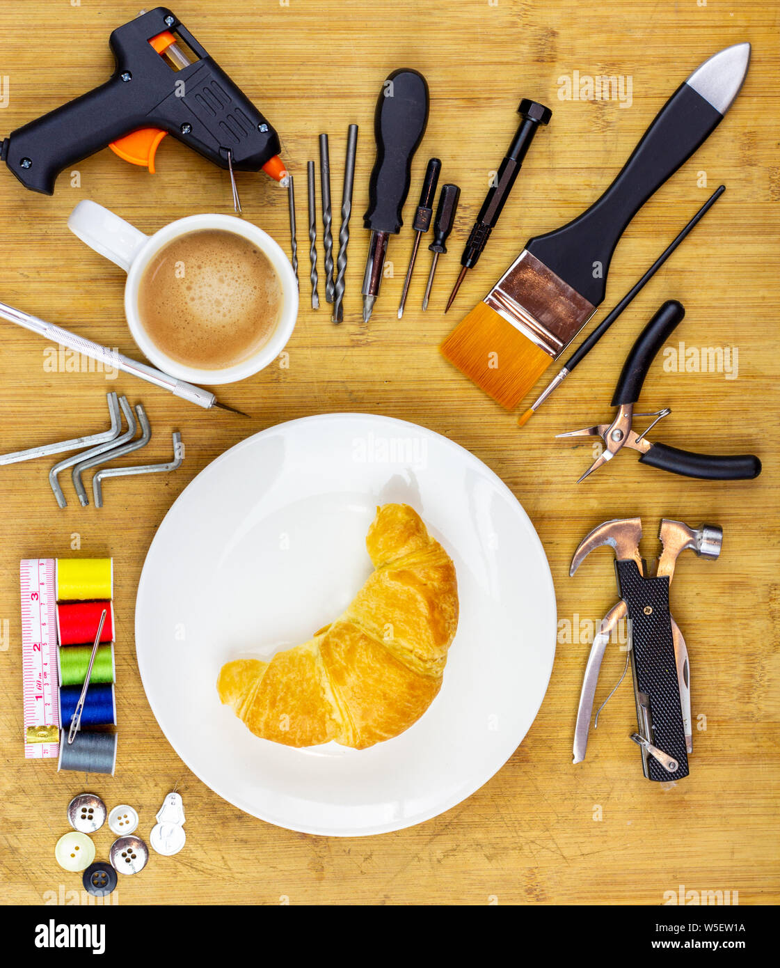 concept illustration for Repair Cafe, plate surrounded by repair tools on wooden work table top, consumer activism to repair household items to reduce Stock Photo
