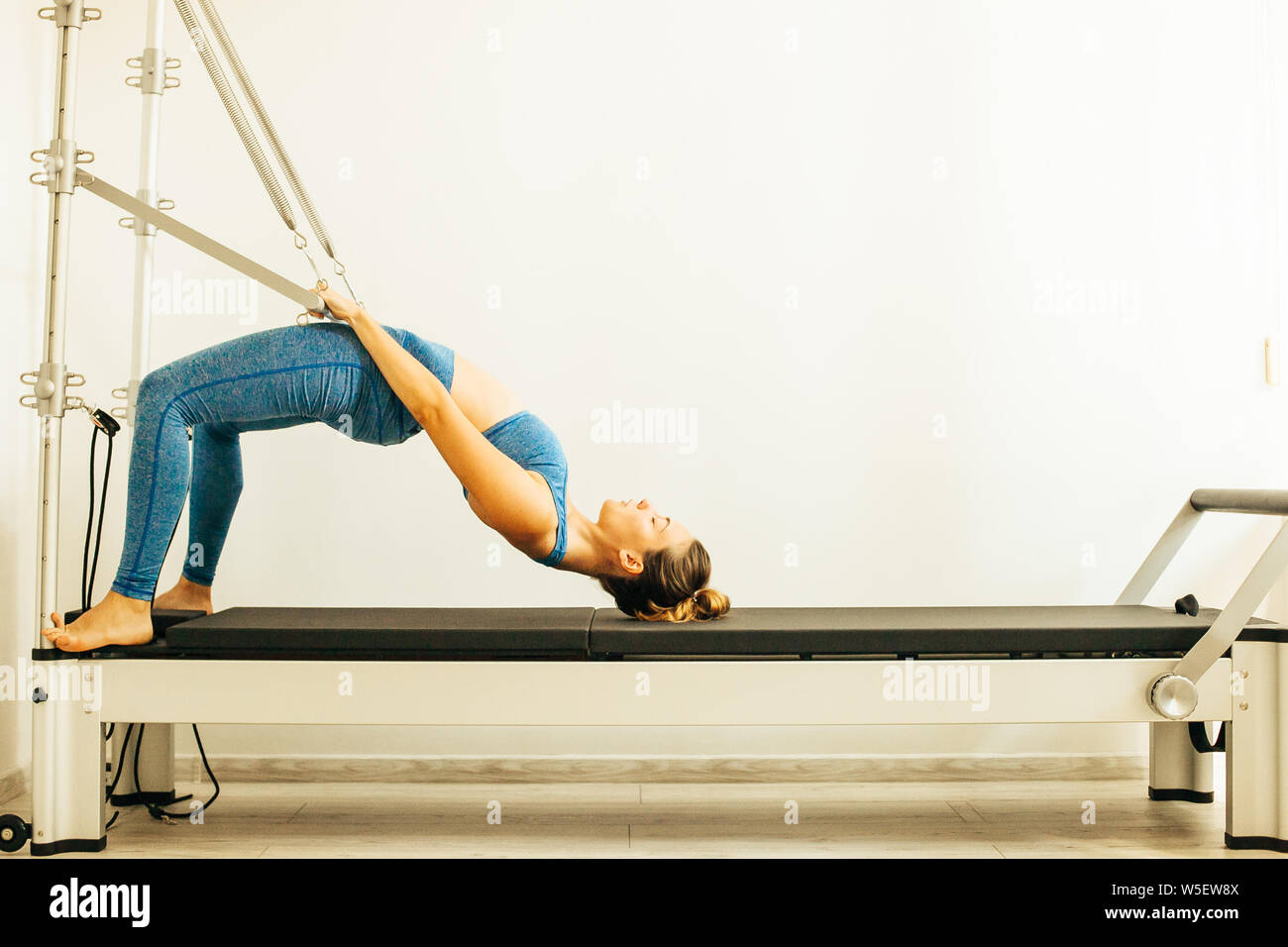 Stretching Pilates exercise being performed on a Reformer Stock Photo