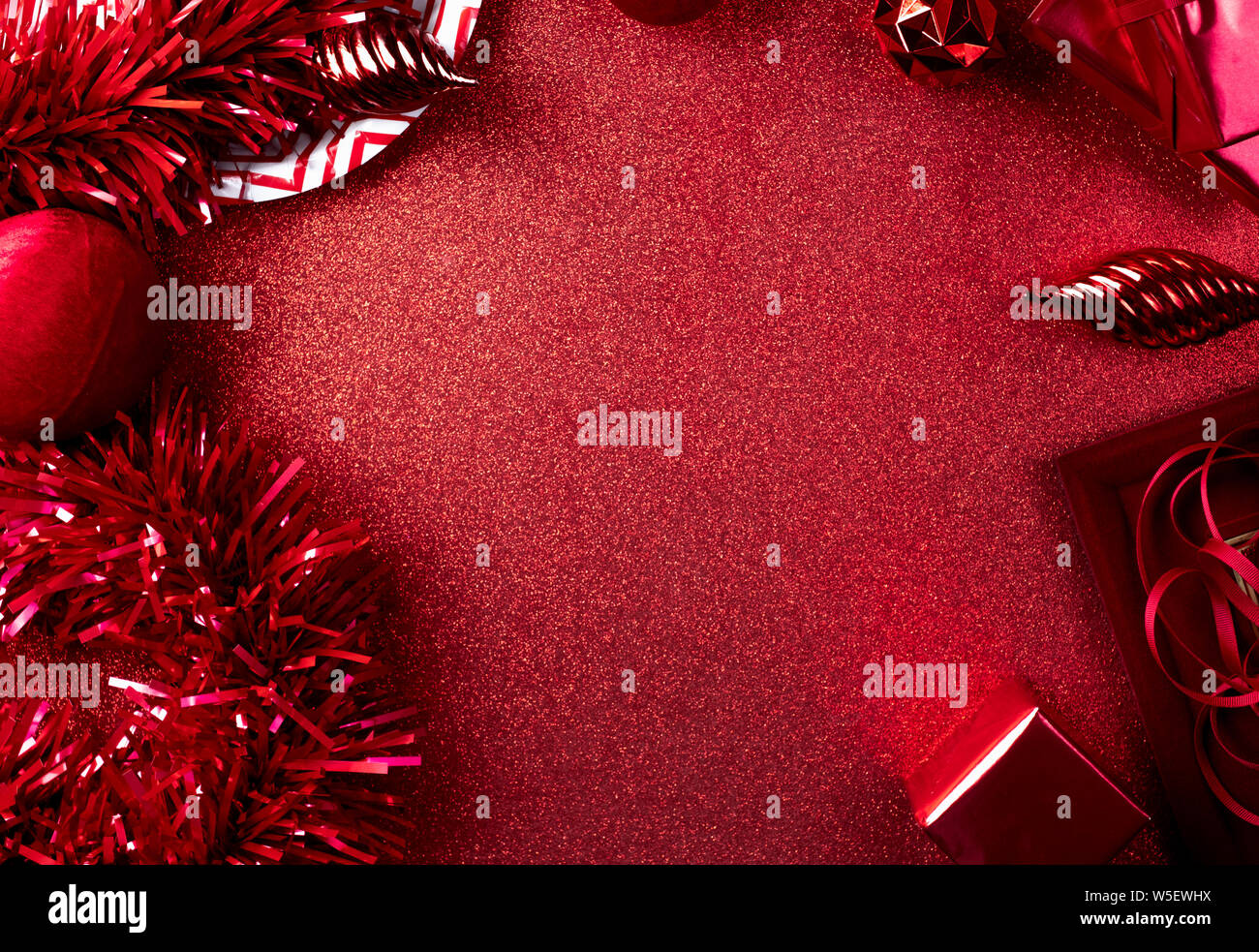 Merry christmas and happy new year red background.top view of tinsel,gift box,ball,ribbon decorate on sparkling table.holiday celebration greeting car Stock Photo