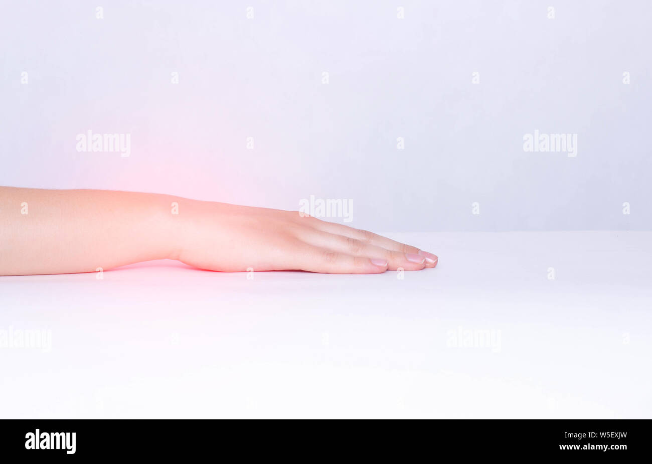 Pain and inflammation in the wrist of a girl, white background, close-up, copy space, ankylosing spondylitis, polyarthritis, rheumatoid arthritis Stock Photo
