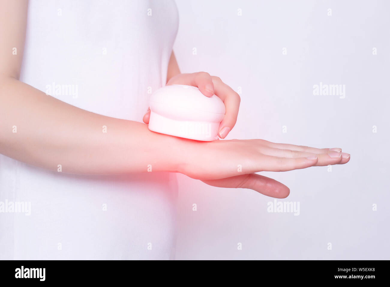 Girl treats a sore wrist joint with the help of physiotherapy and magnet laser treatment, white background, tendonitis, posttraumatic polyarthritis Stock Photo