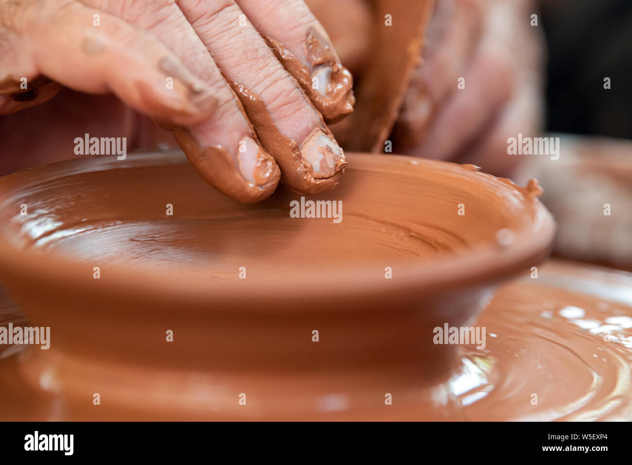 Hands of the potter. The potter makes pottery dishes on potter's wheel