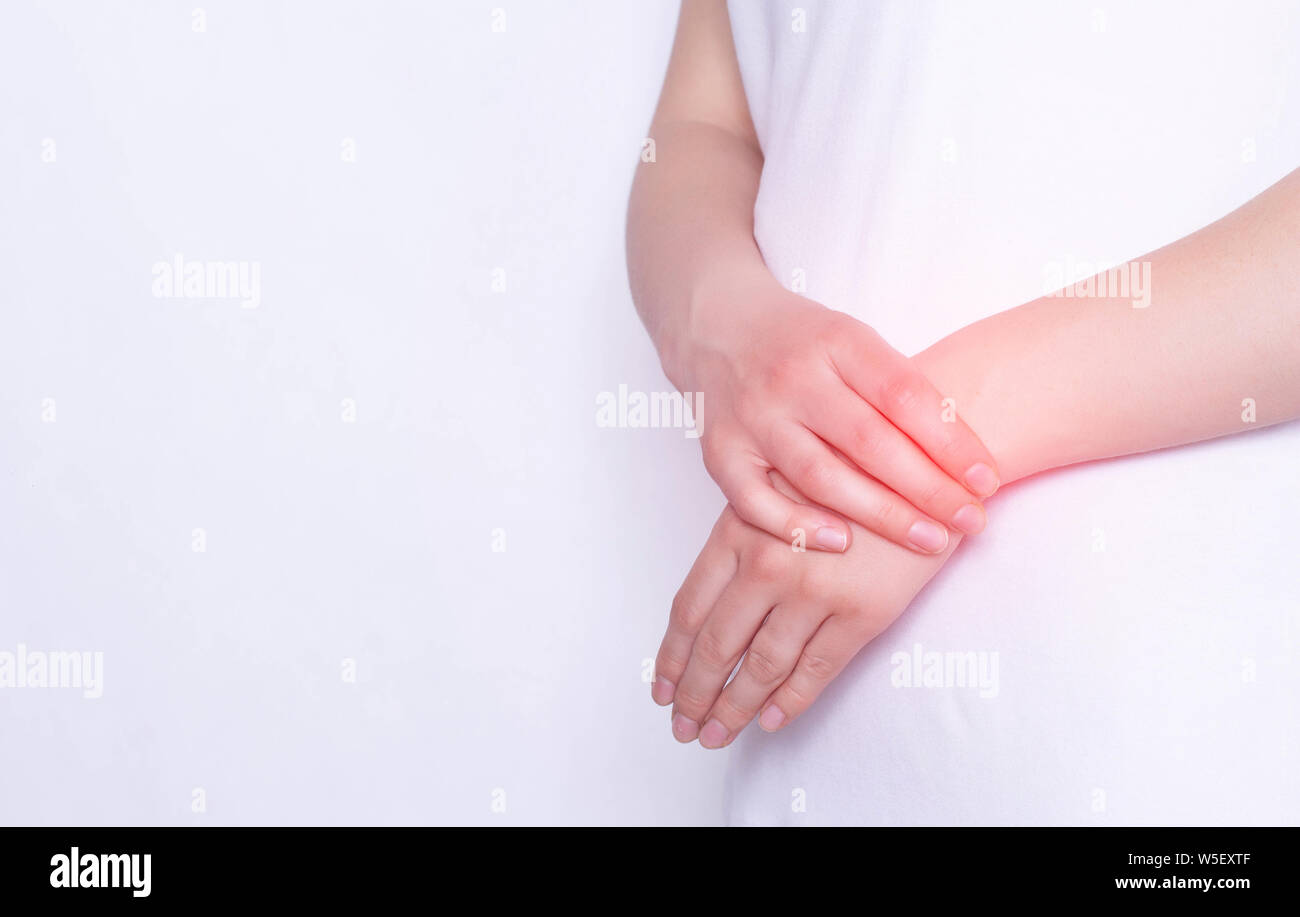 Pain and inflammation in the hand on the wrist of a girl, white background, copy space, injury Stock Photo
