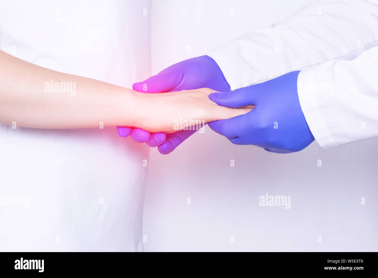 Doctor examines a girl's wrist joint for sprain, inflammation and pain in her wrist, close-up, arthrosis, chronic pain Stock Photo
