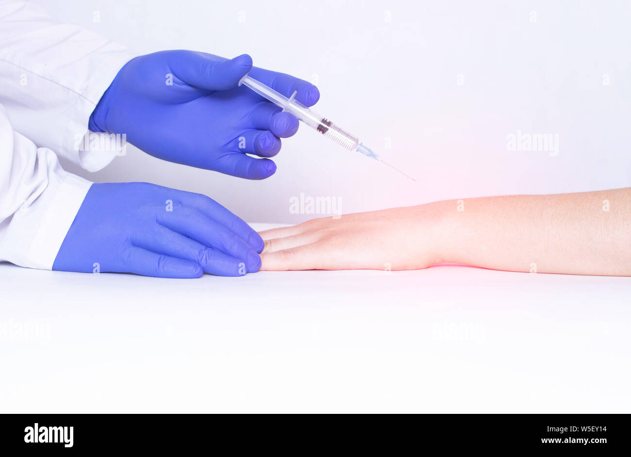 Doctor injects blockade into wrist joint with chondroprotector and analgesic drug, close-up, medical, ozone therapy, corticosteroid Stock Photo