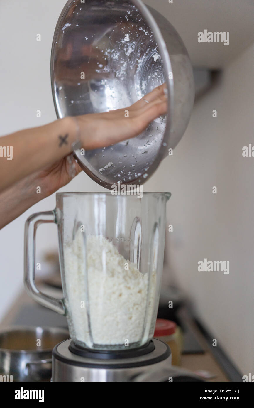 Woman Pouring Cottage Cheese Into A Blender In The Kitchen Stock