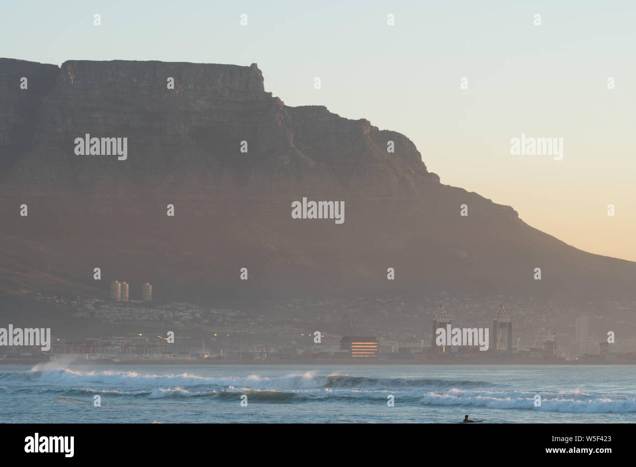 close up of a section of Table Mountain, Cape Town looking across the sea at sunset and a view of the upper cable car station on the top and the city Stock Photo