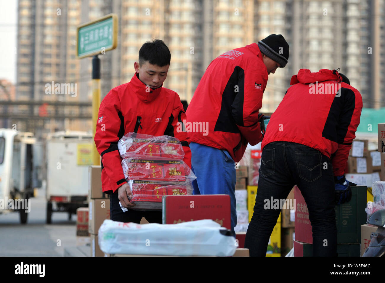 Chinese couriers of an express delivery company sort out parcels from