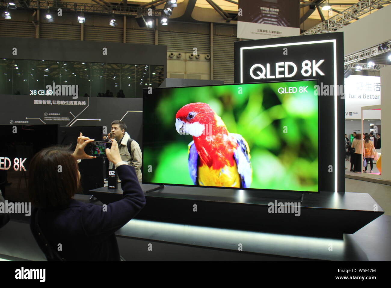 A visitor takes a picture of a Samsung 8K QLED TV on display during the Appliance & Electronics World Expo 2019 (AWE 2019) in Shanghai, China, 14 Marc Stock Photo