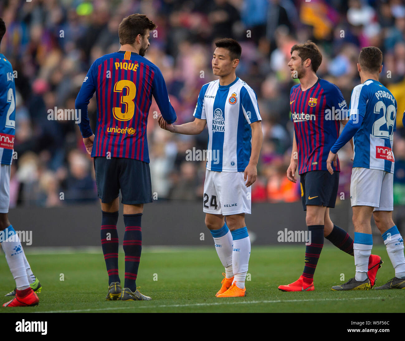 Wu Lei of RCD Espanyol, center, is greeted by Gerard Pique of FC Barcelona  after RCD Espanyol was defeated by FC Barcelona during their 29th round mat  Stock Photo - Alamy