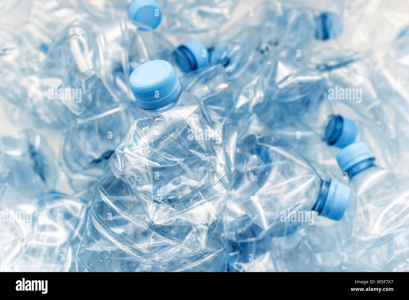 stack of compressed plastic bottles with blue caps Stock Photo