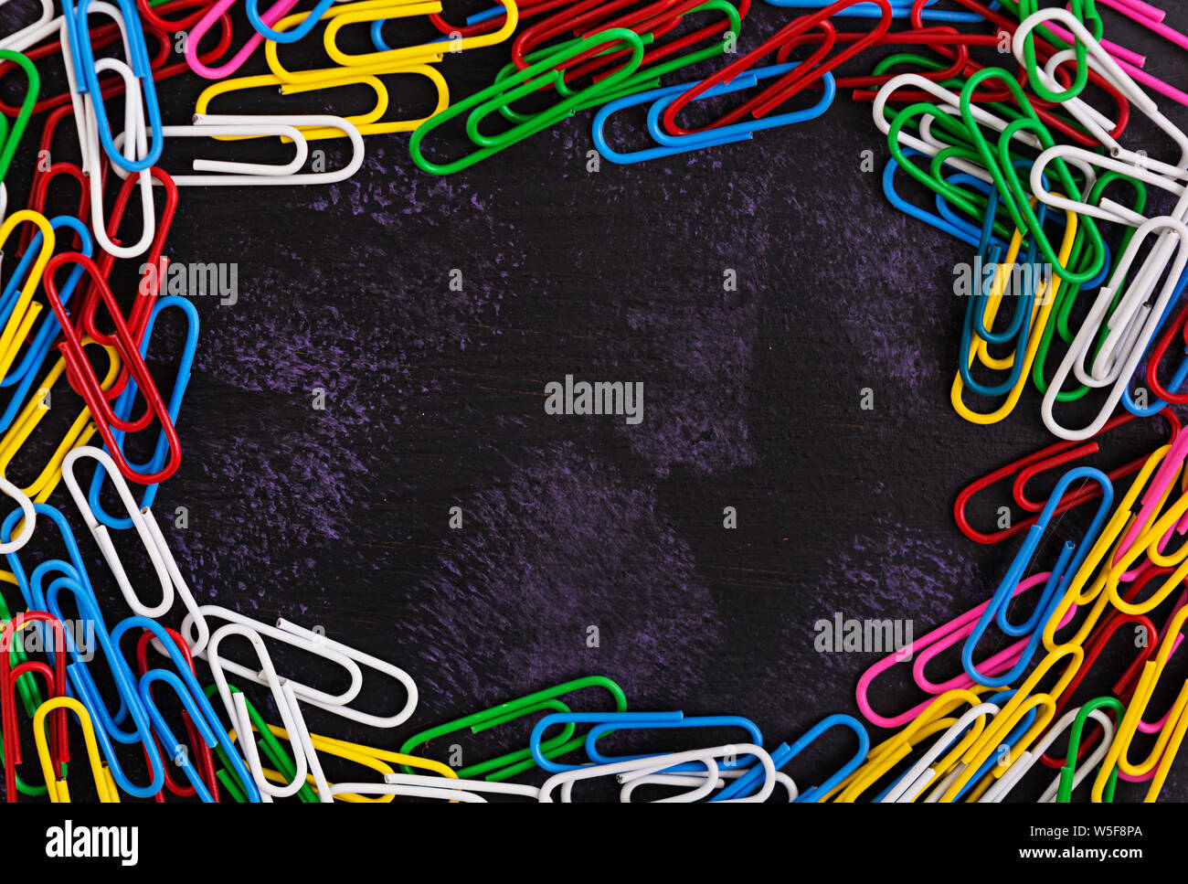 Colored paper clips isolated on dark background Stock Photo