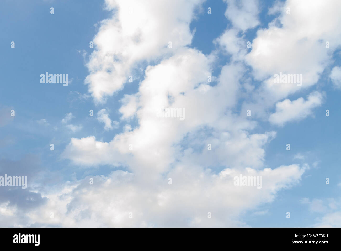 White fluffy clouds in the blue sky in summer Stock Photo - Alamy