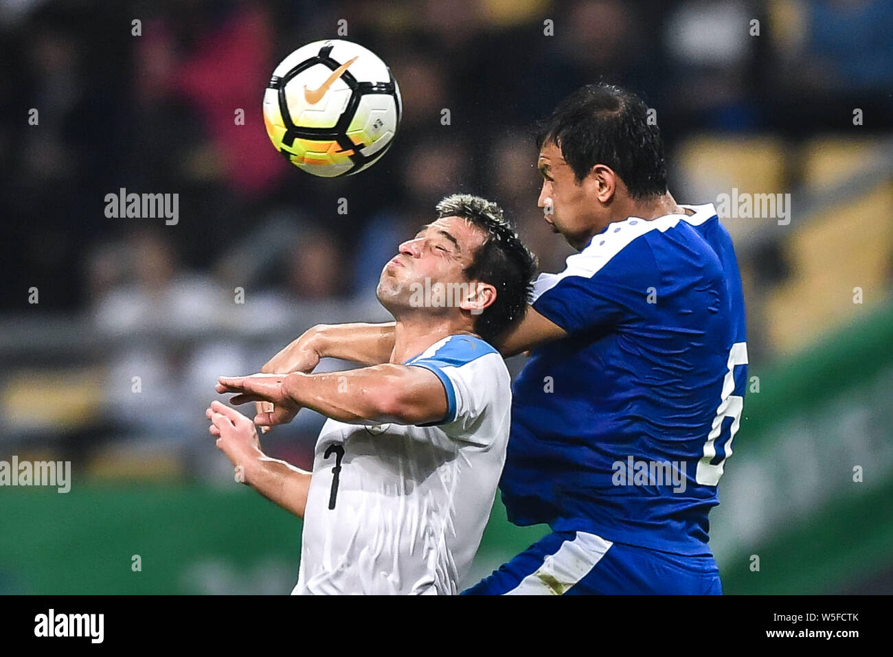 Davron Hashimov of Uzbekistan, right, challenges Nicolas Lodeiro of Uruguay during their semi-final match of the 2019 China Cup International Football Stock Photo