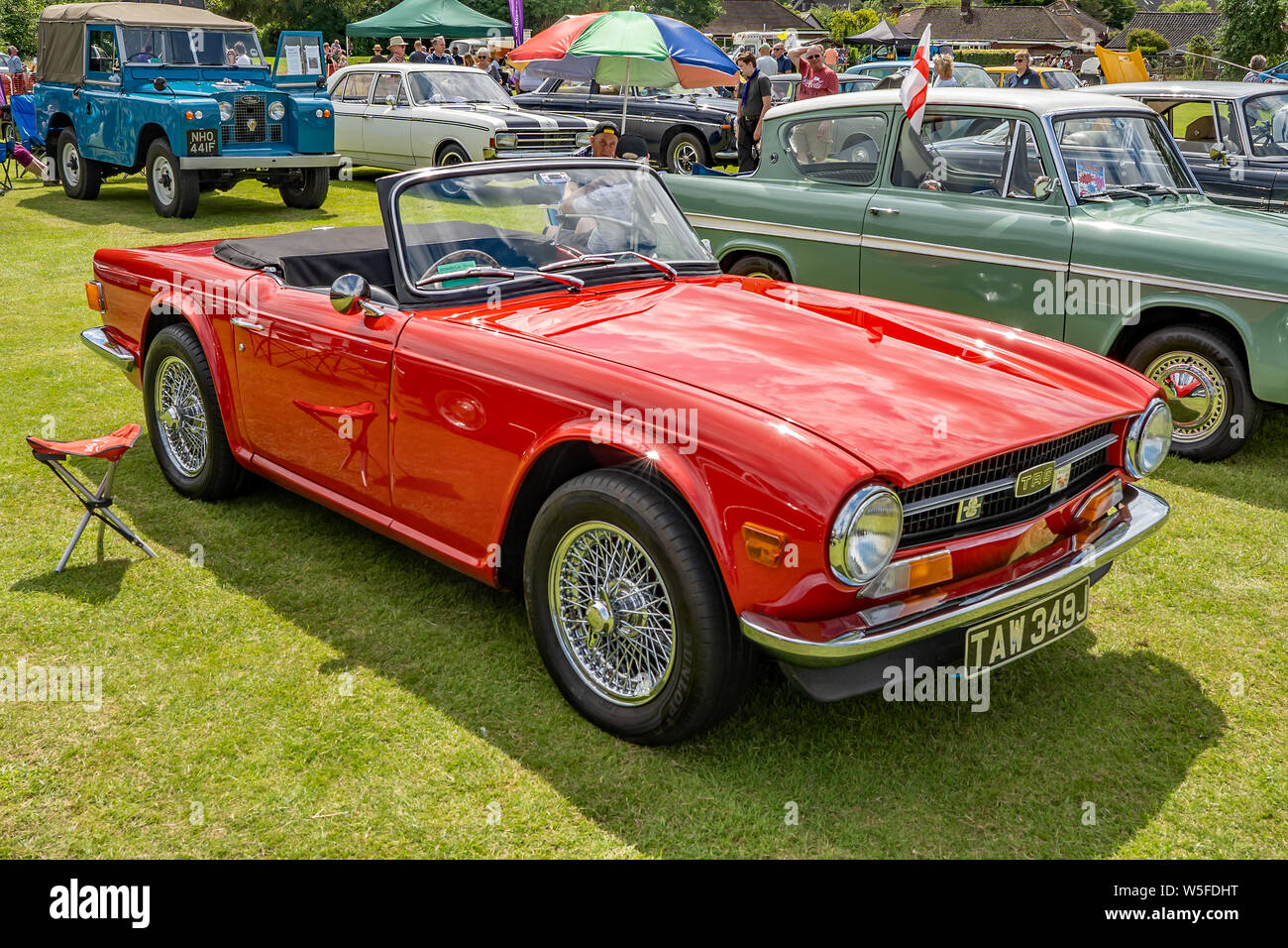Side view of a vintage Triumph TR6 sports car, in brilliant red, on