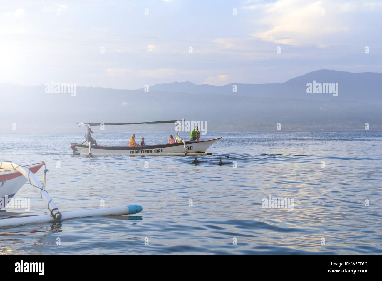 Sunrise view over tourists waiting for wild dolphin at Lovina beach in Bali, Indonesia. Stock Photo