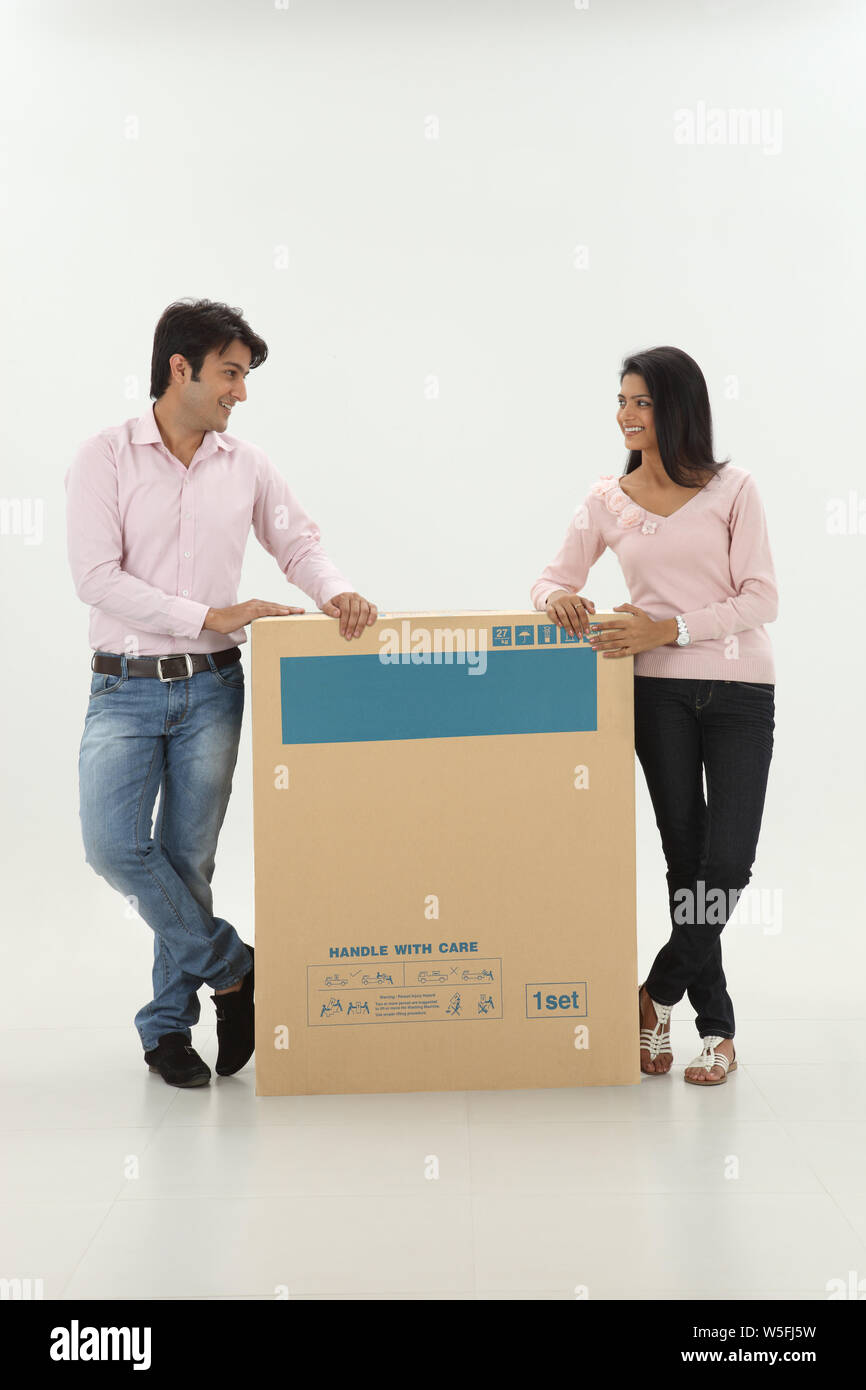 Couple with a cardboard box smiling Stock Photo - Alamy