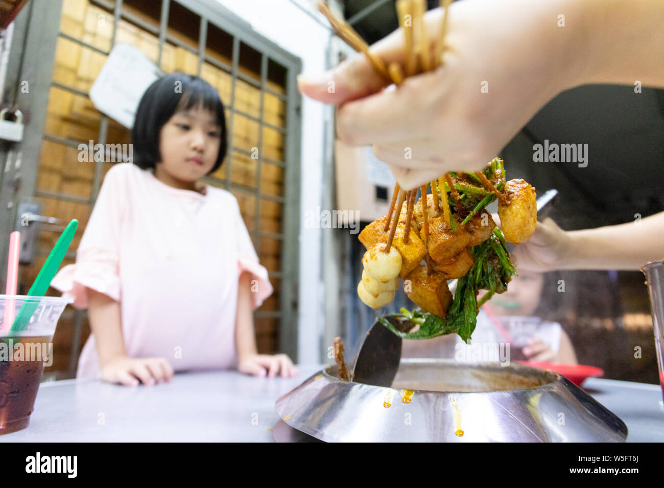 Asian Little Chinese Girl eating hot pot in a restaurant of Melaka Stock Photo