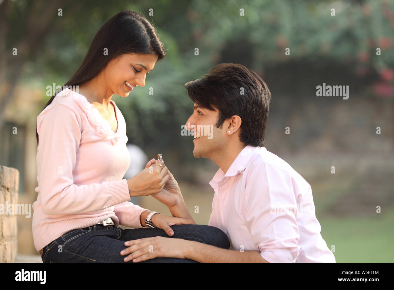 Man giving an engagement ring to a woman and smiling Stock Photo - Alamy