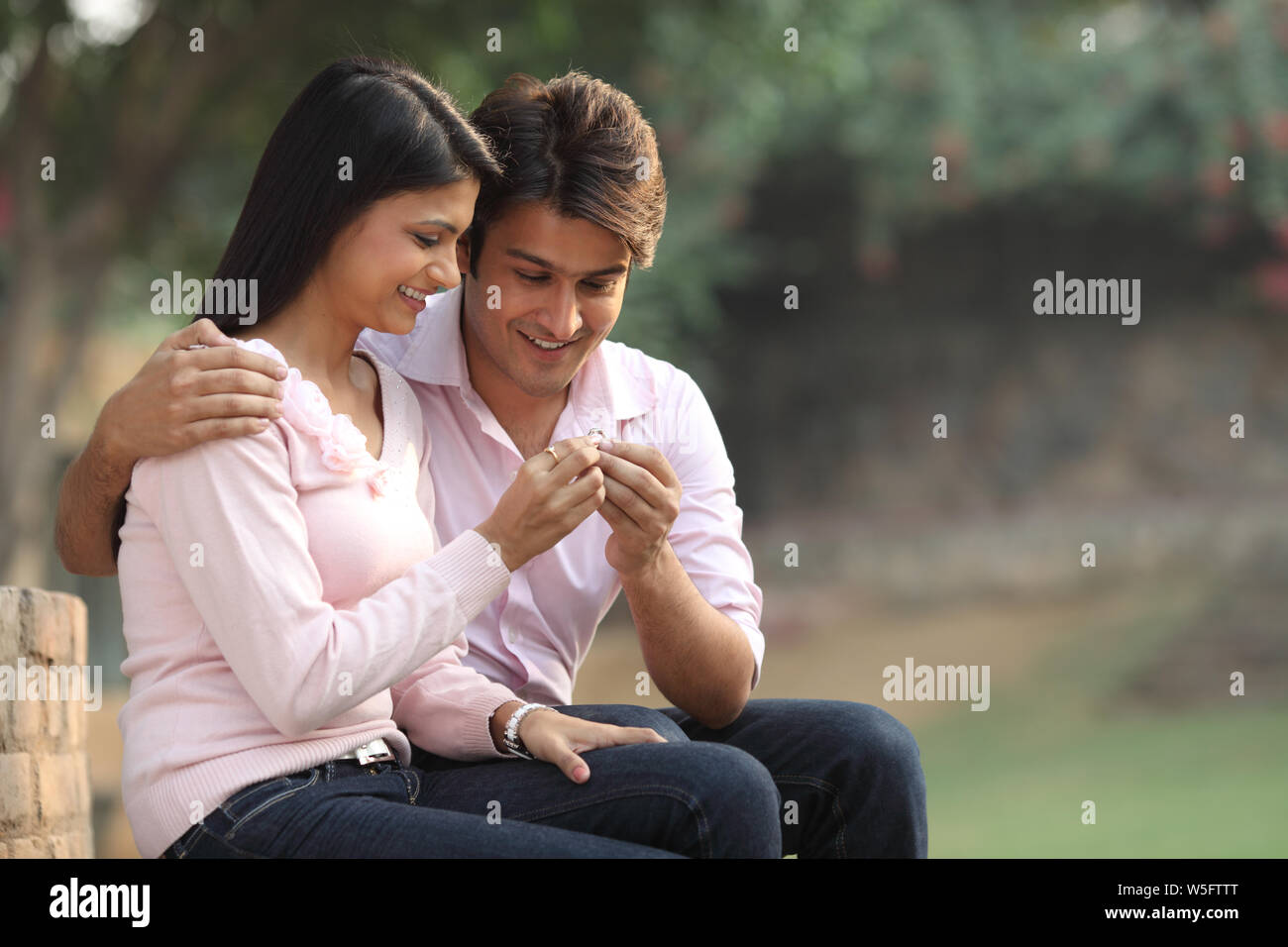 Man giving an engagement ring to a woman and smiling Stock Photo - Alamy