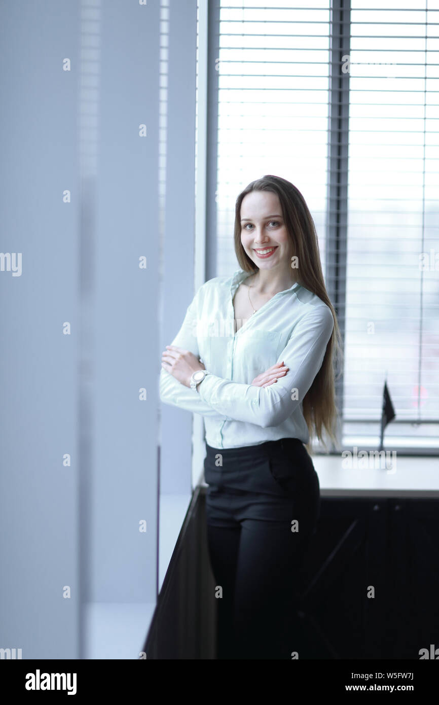 business woman standing near the window in the corridor of the office ...