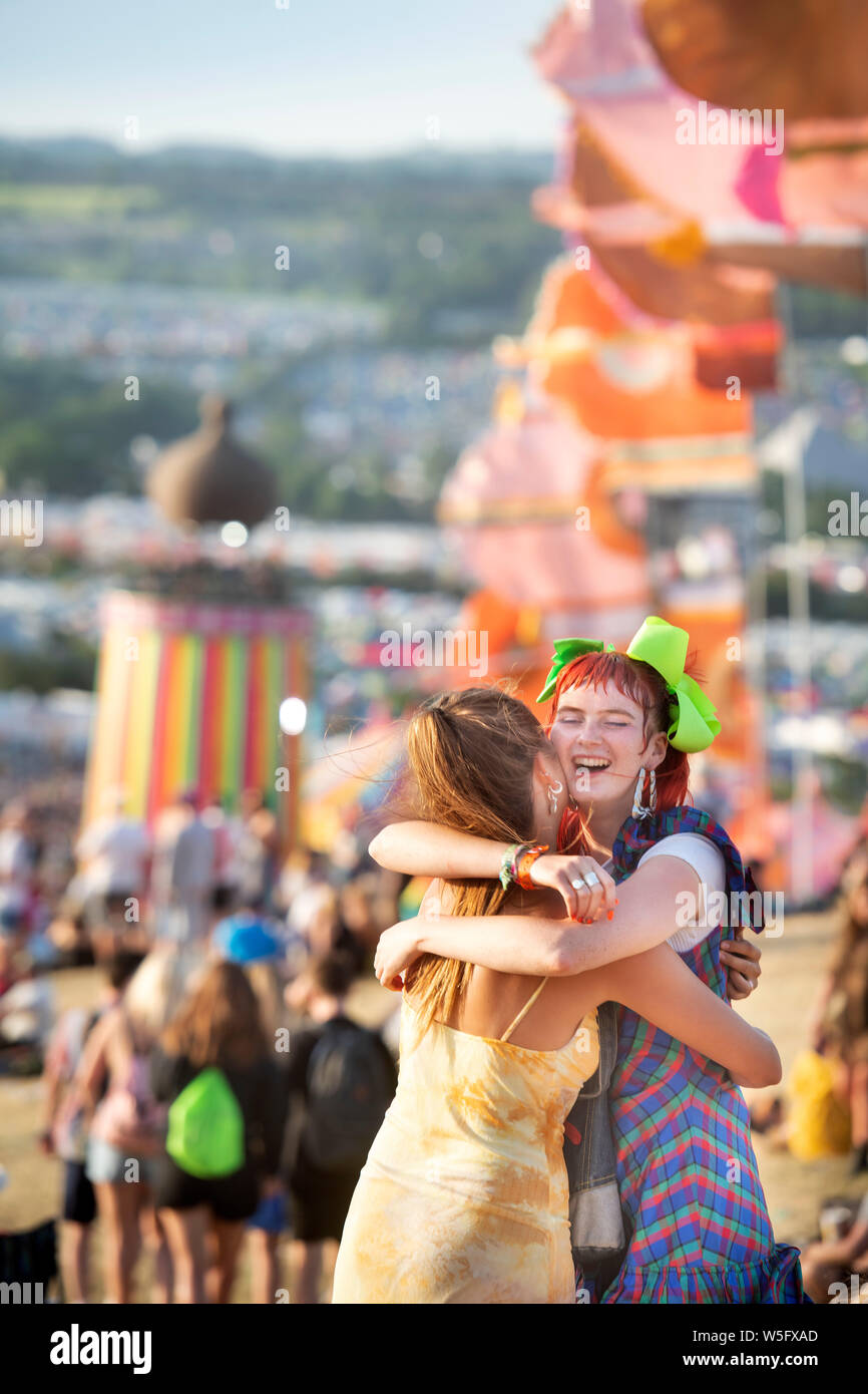 Two girls embracing in the Park area at Glastonbury 2019 Stock Photo