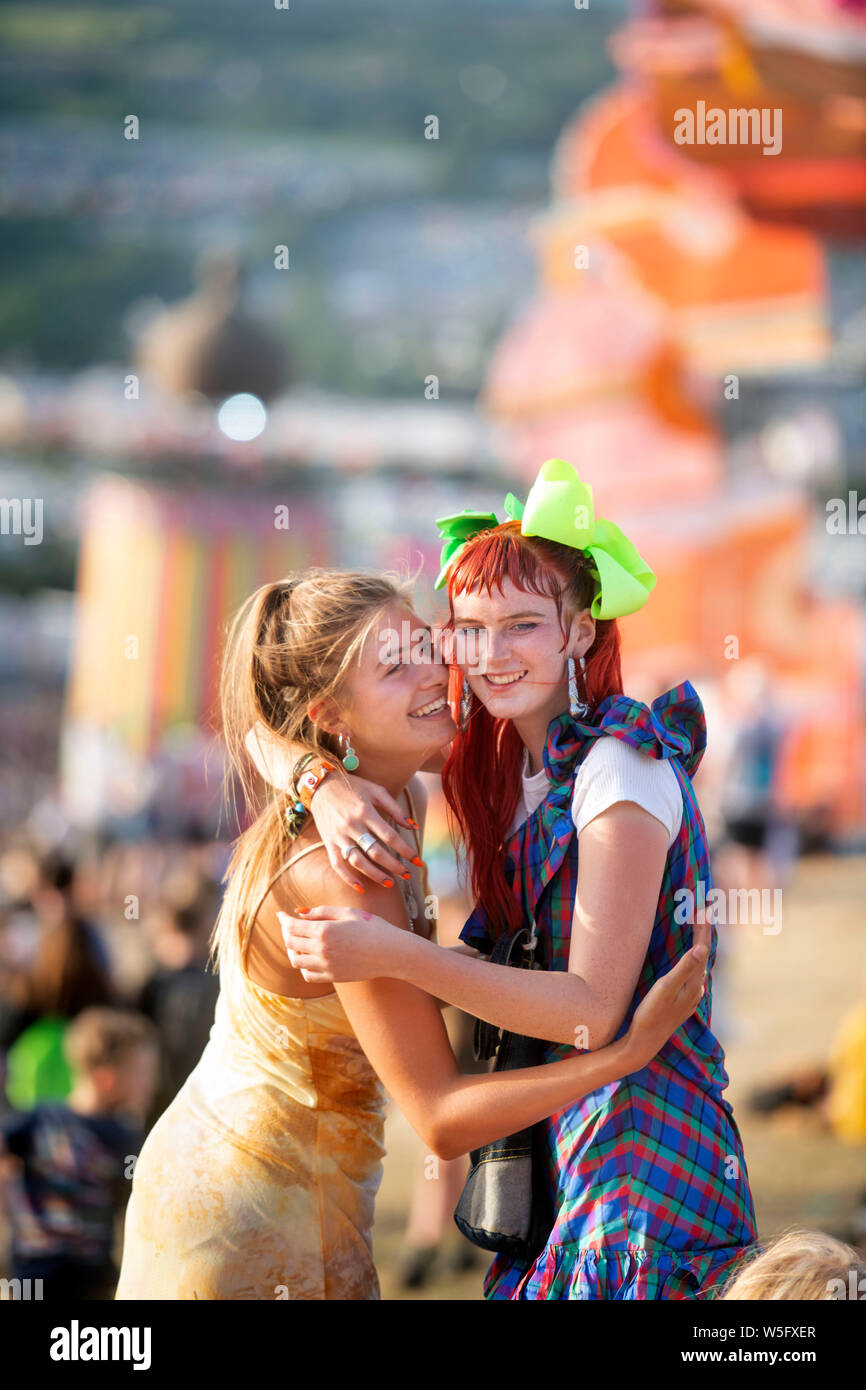 Two girls embracing in the Park area at Glastonbury 2019 Stock Photo