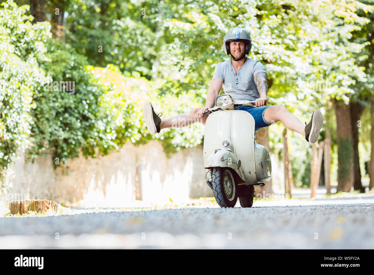 Carefree young man driving scooter Stock Photo