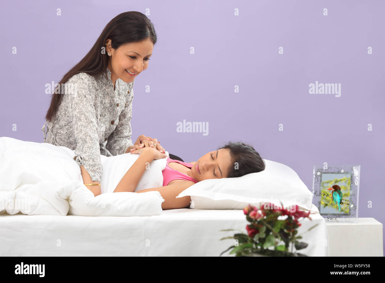 Woman caring for her daughter while sleeping Stock Photo