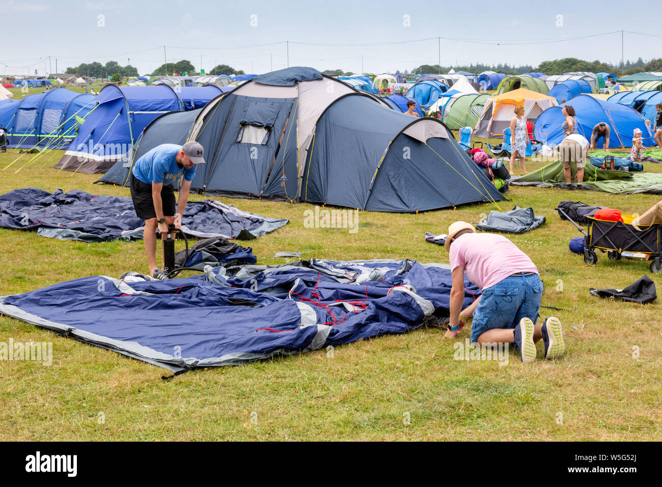 Festival goers erecting their tents on the first day of Camp Bestival, Dorset, UK Stock Photo