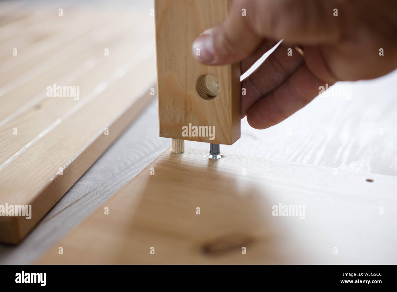 Man assembling wooden furniture at home, close up image. Stock Photo