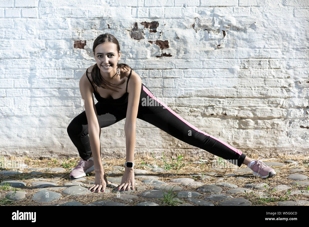 Fitness sport girl in fashion sportswear doing yoga fitness exercise in the street, outdoor sports, urban style Stock Photo