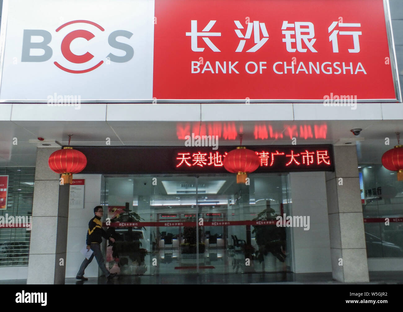 --FILE--Local residents walk past a branch of Bank of Changsha (BCS) in Guangzhou city, south China's Guangdong province, 4 February 2014.   Bank of C Stock Photo