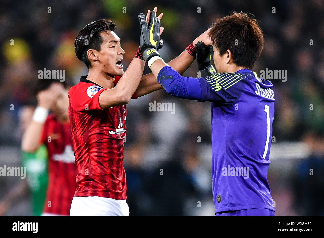 Shusaku Nishikawa, right, of Japan's Urawa Red Diamonds F.C. celebrates with Tomoaki Makino as they compete against China's Beijing Guoan F.C. in thei Stock Photo