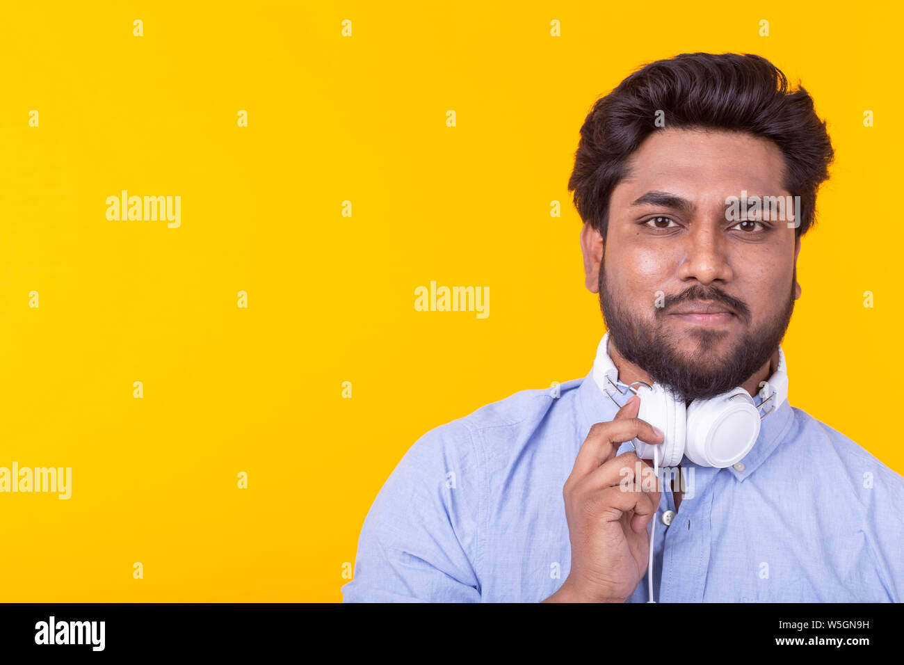 Positive young indian male listens to your favorite online radio using