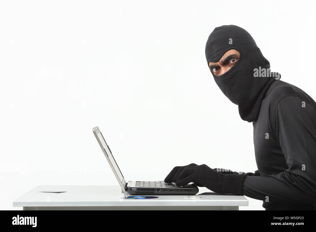 Hacker stealing information from laptop Stock Photo