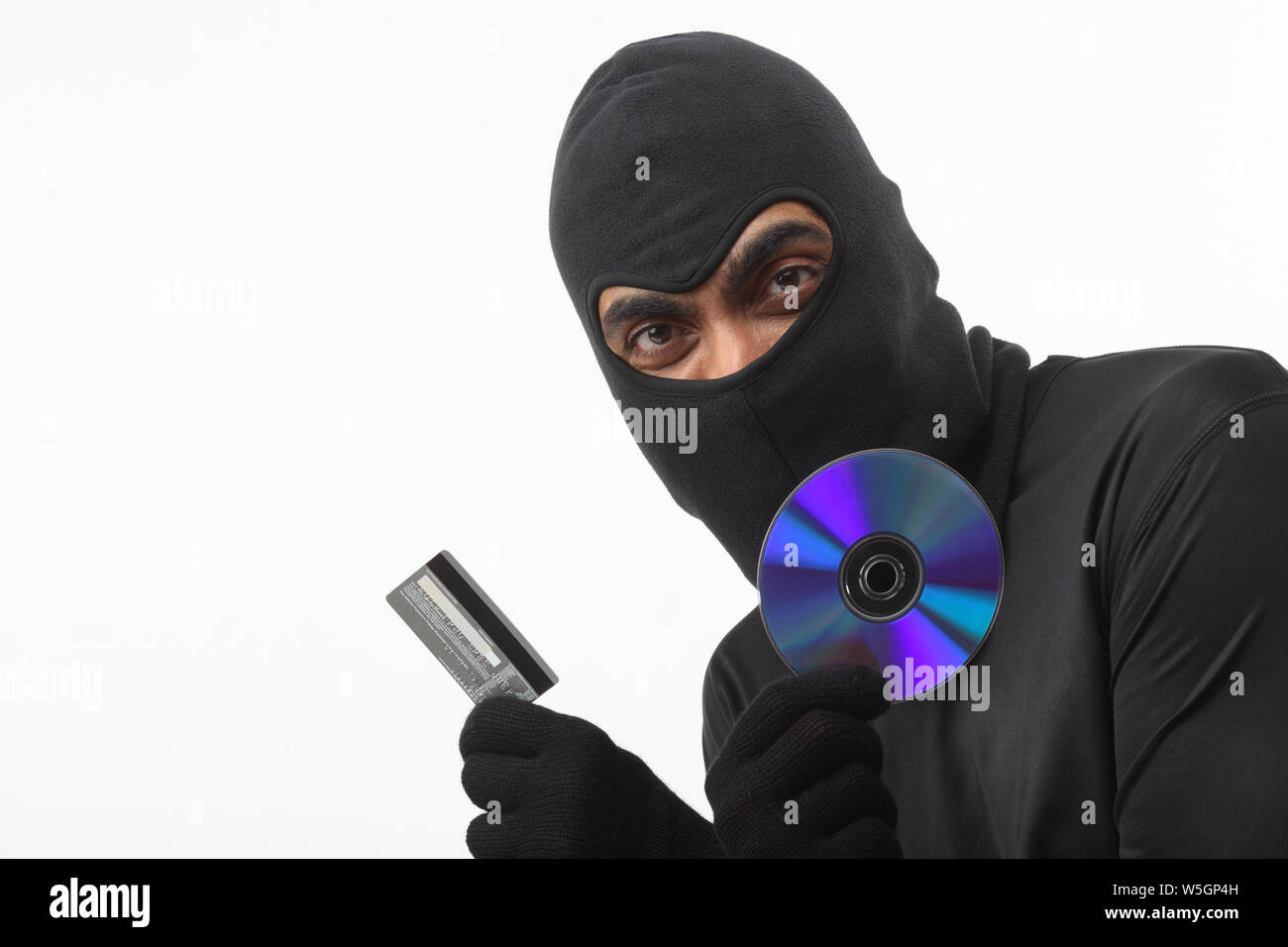 Hacker showing a pirated compact disc with credit card Stock Photo
