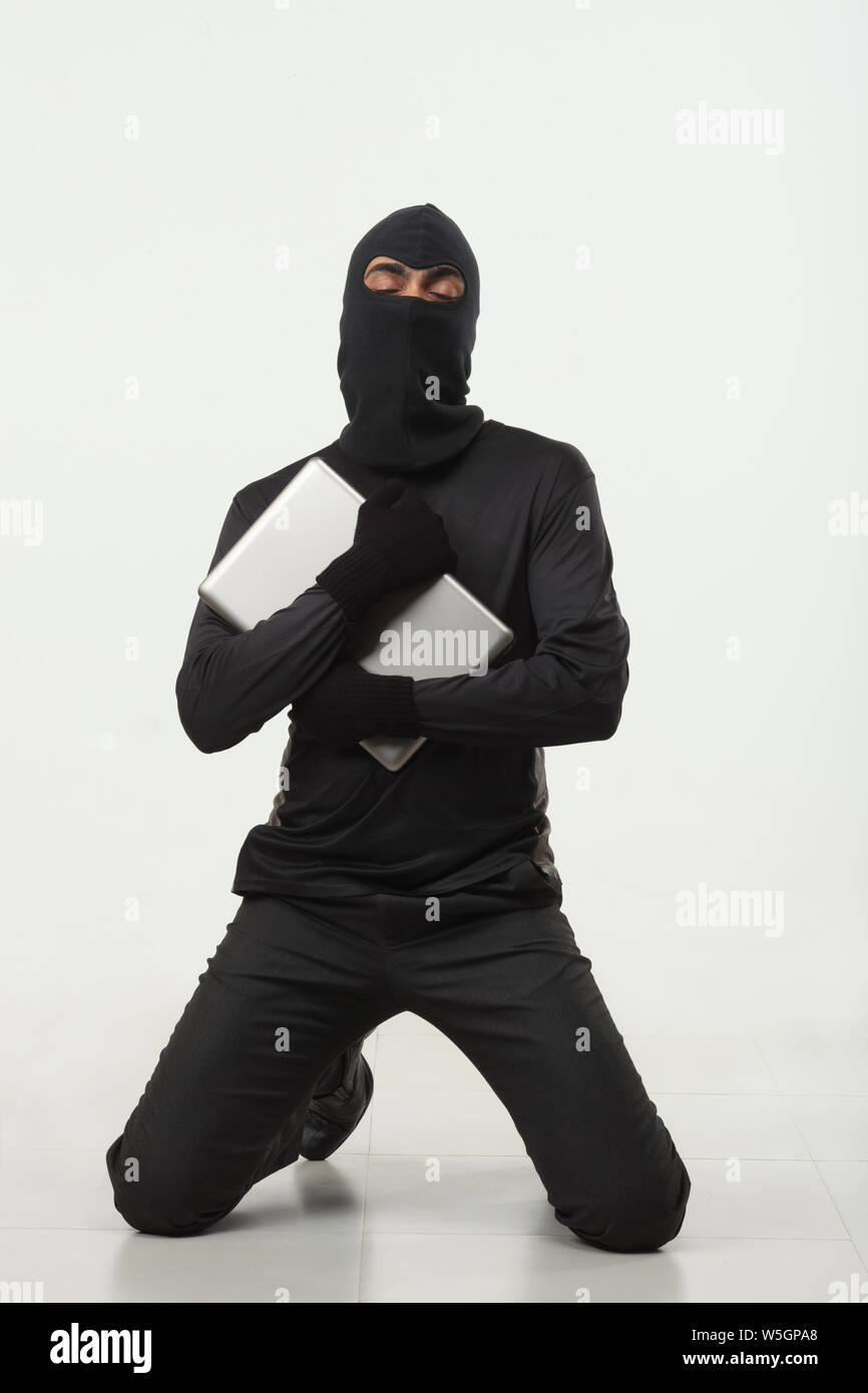 Hacker holding a laptop Stock Photo - Alamy