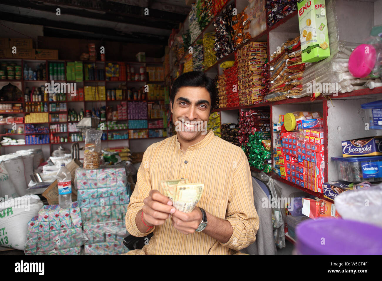 Shopkeeper counting money in grocery shop Stock Photo - Alamy