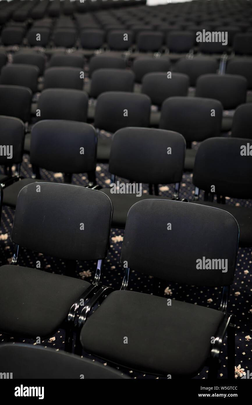 Black chairs in big empty congress room, front view Stock Photo