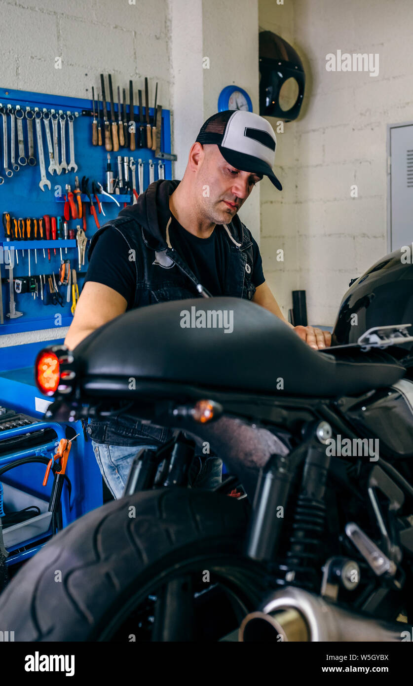 Mechanic checking motorcycle Stock Photo Alamy