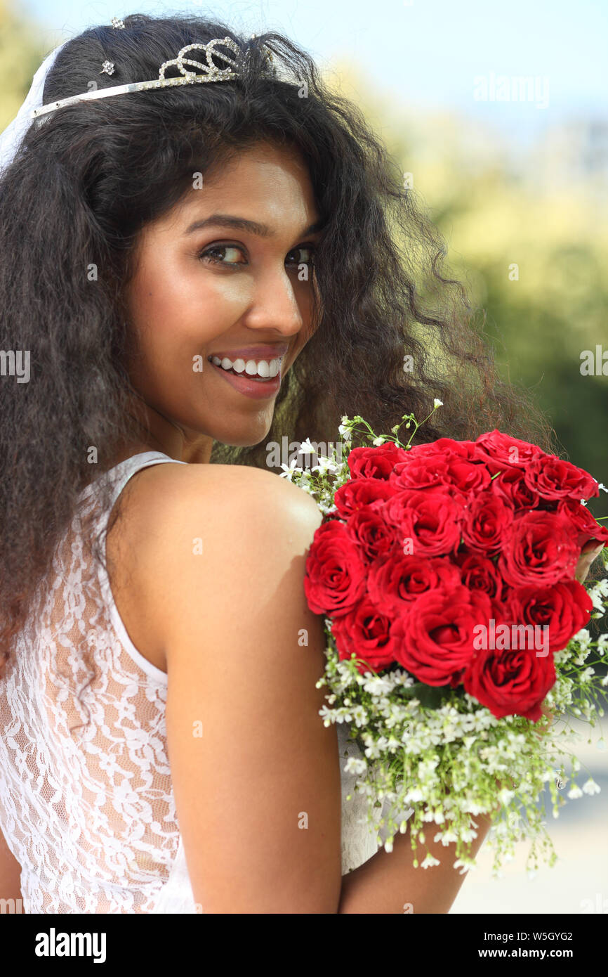 Portrait of a bride holding a bouquet and smiling Stock Photo - Alamy