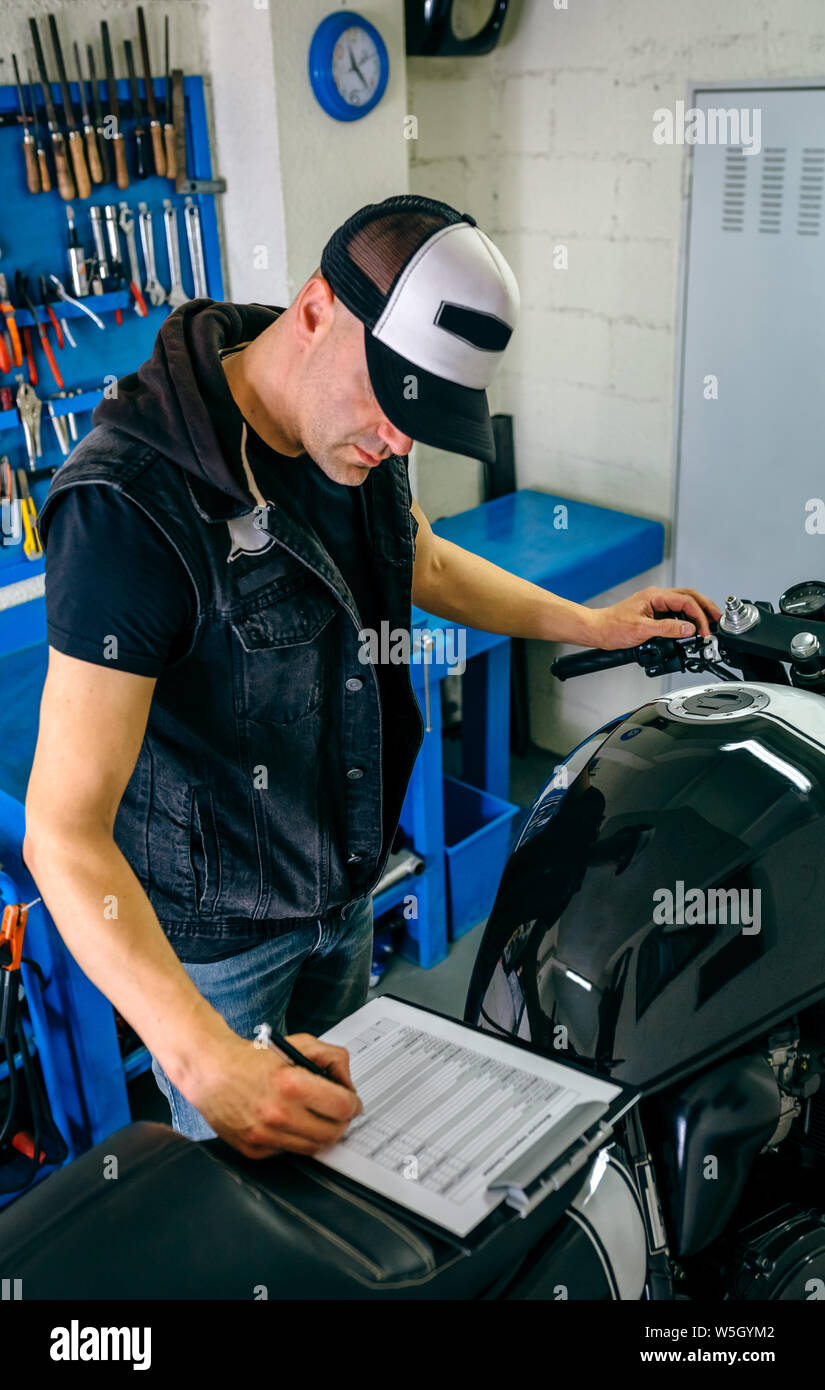 Mechanic checking motorcycle Stock Photo Alamy