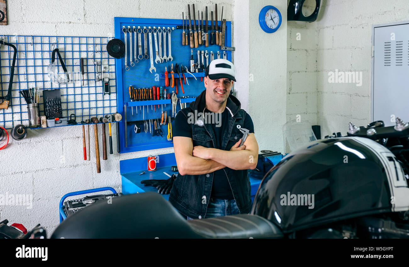 Mechanic posing with a motorcycle Stock Photo