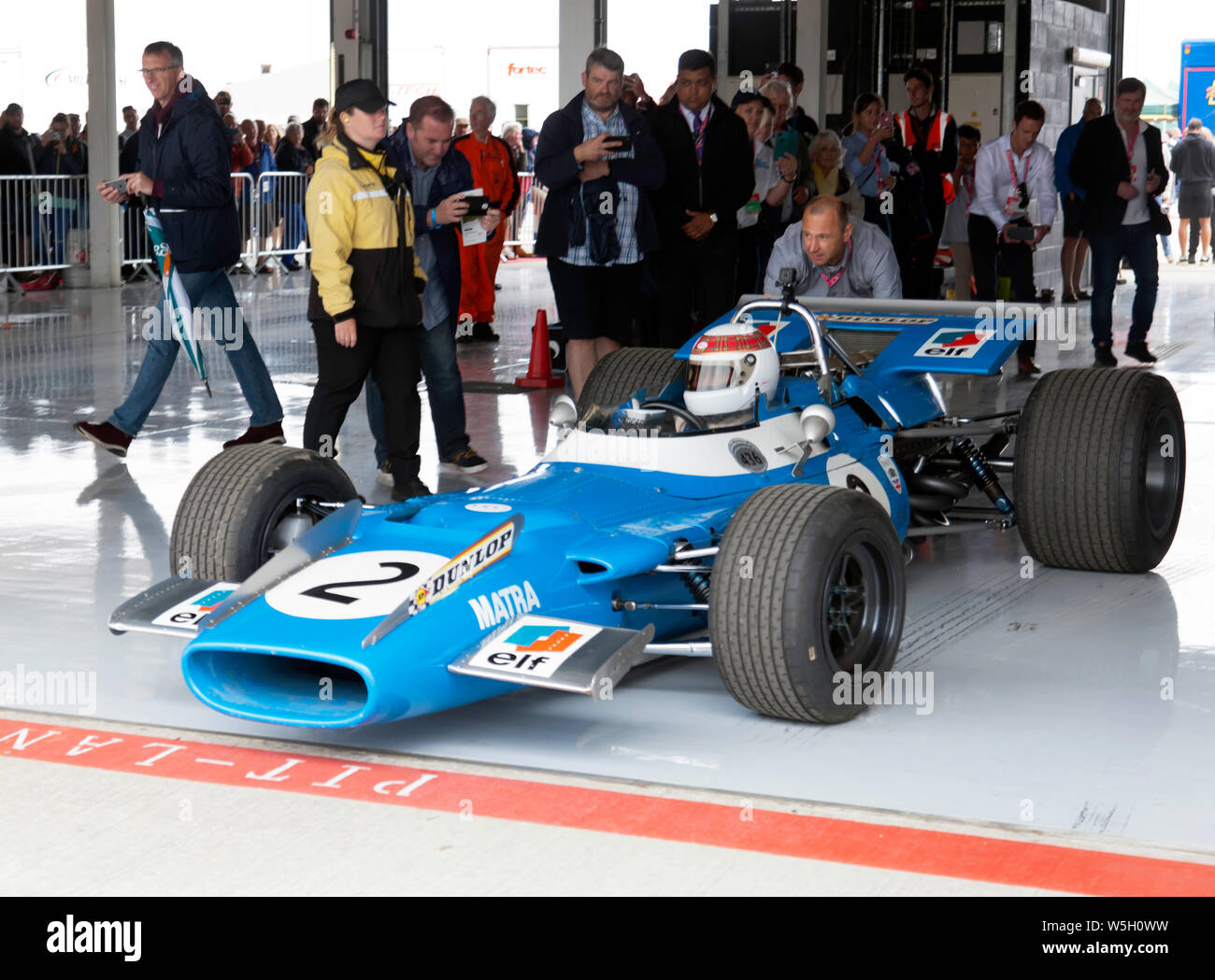 Sir Jackie Stewart being pushed into the pit lane, in the cockpit of  his 1969 championship-winning Matra MS80-02, before completing some high-speed laps  around Silverstone Stock Photo