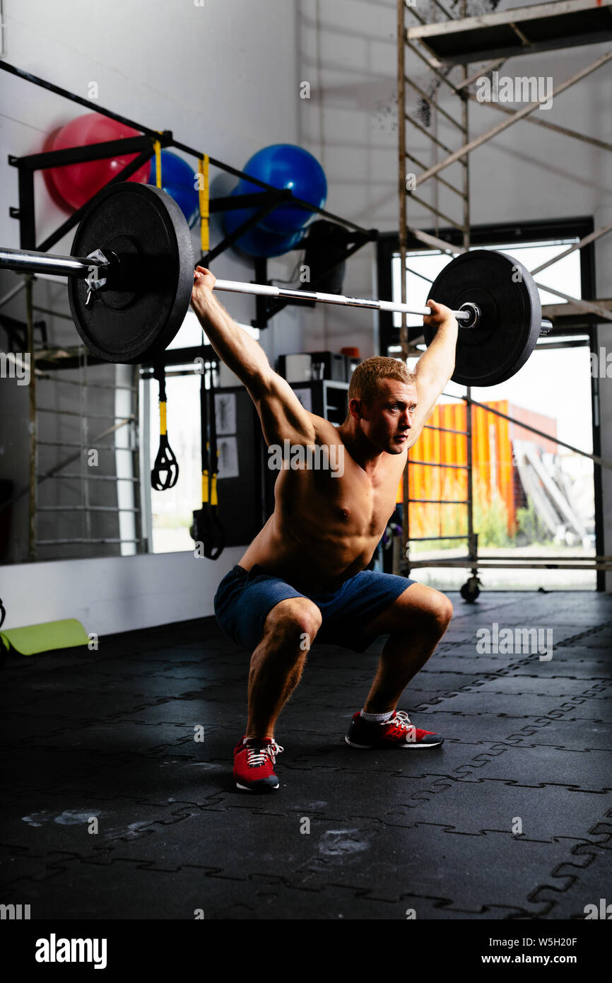 Muscular man with barbell in a workout Stock Photo
